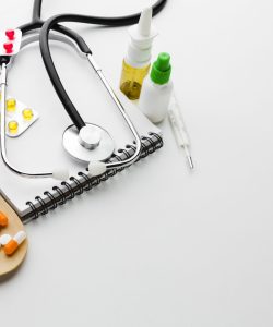 wooden spoon filled with pills stethoscope
